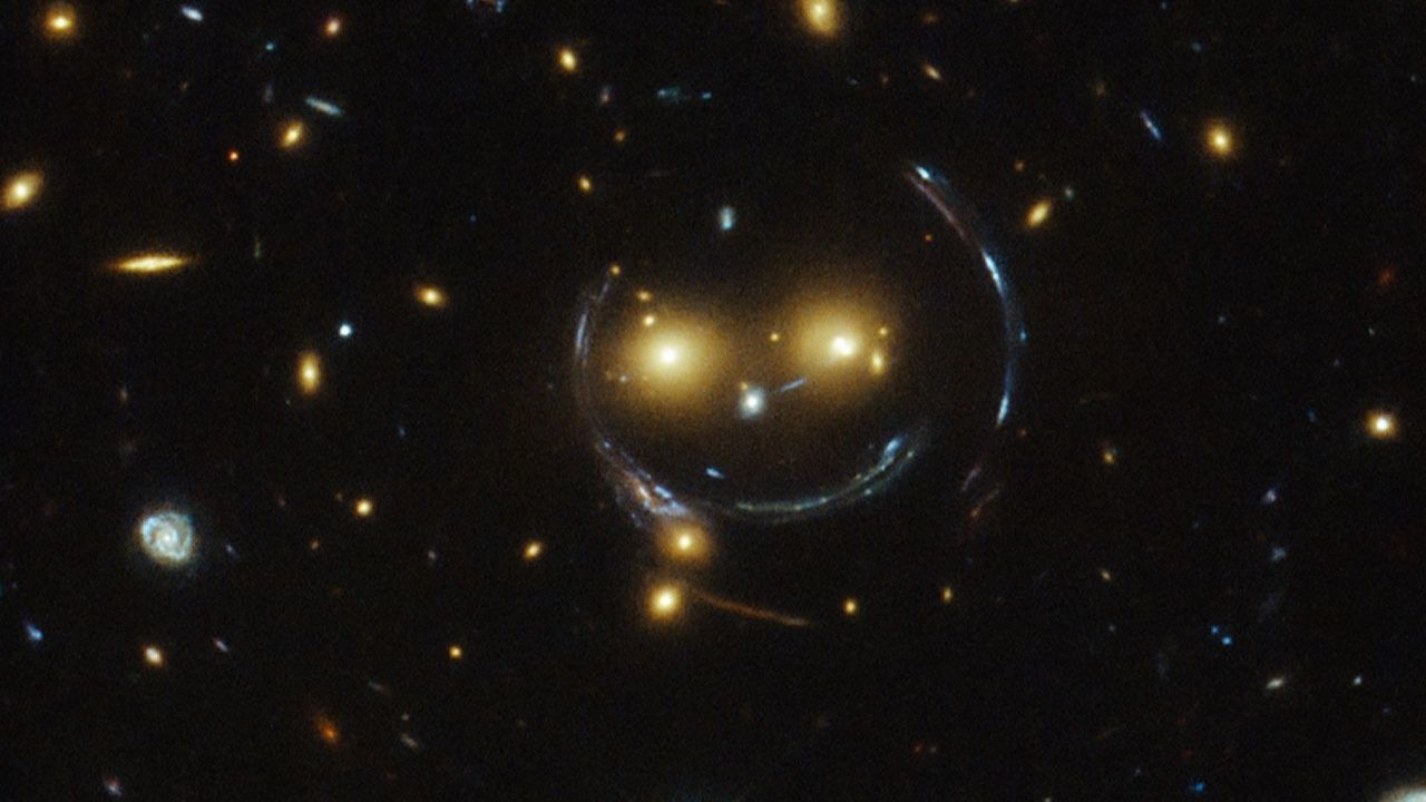 Hubble’dan Dikkat Çeken Kare: Uzayda Gülümseyen Galaksi Kümesi